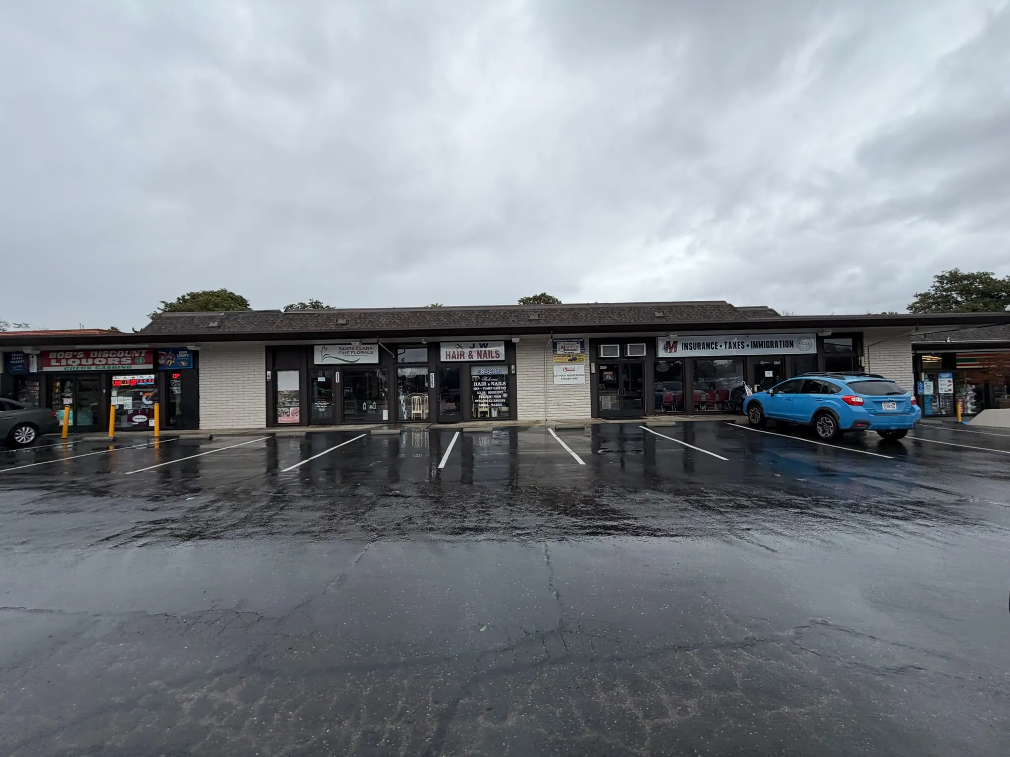Storefronts across the parking lot after rain