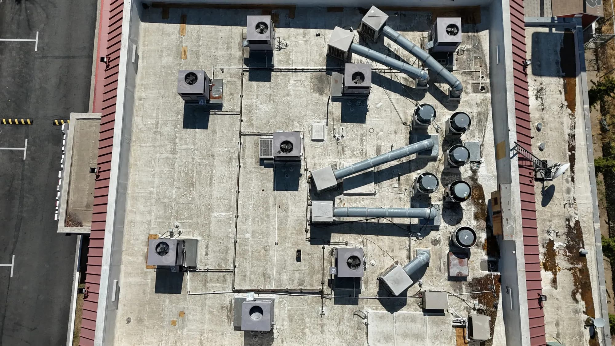 Straight-down drone view of a retail roof with rooftop HVAC units and ductwork