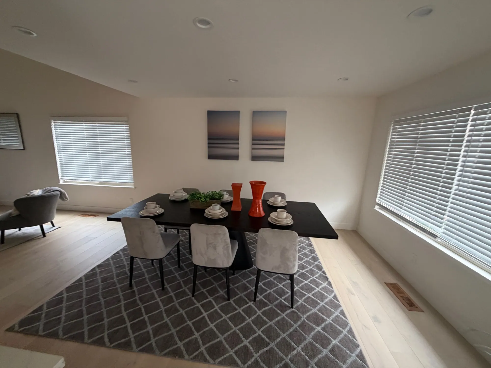 Staged dining room with new light plank floors and wide windows