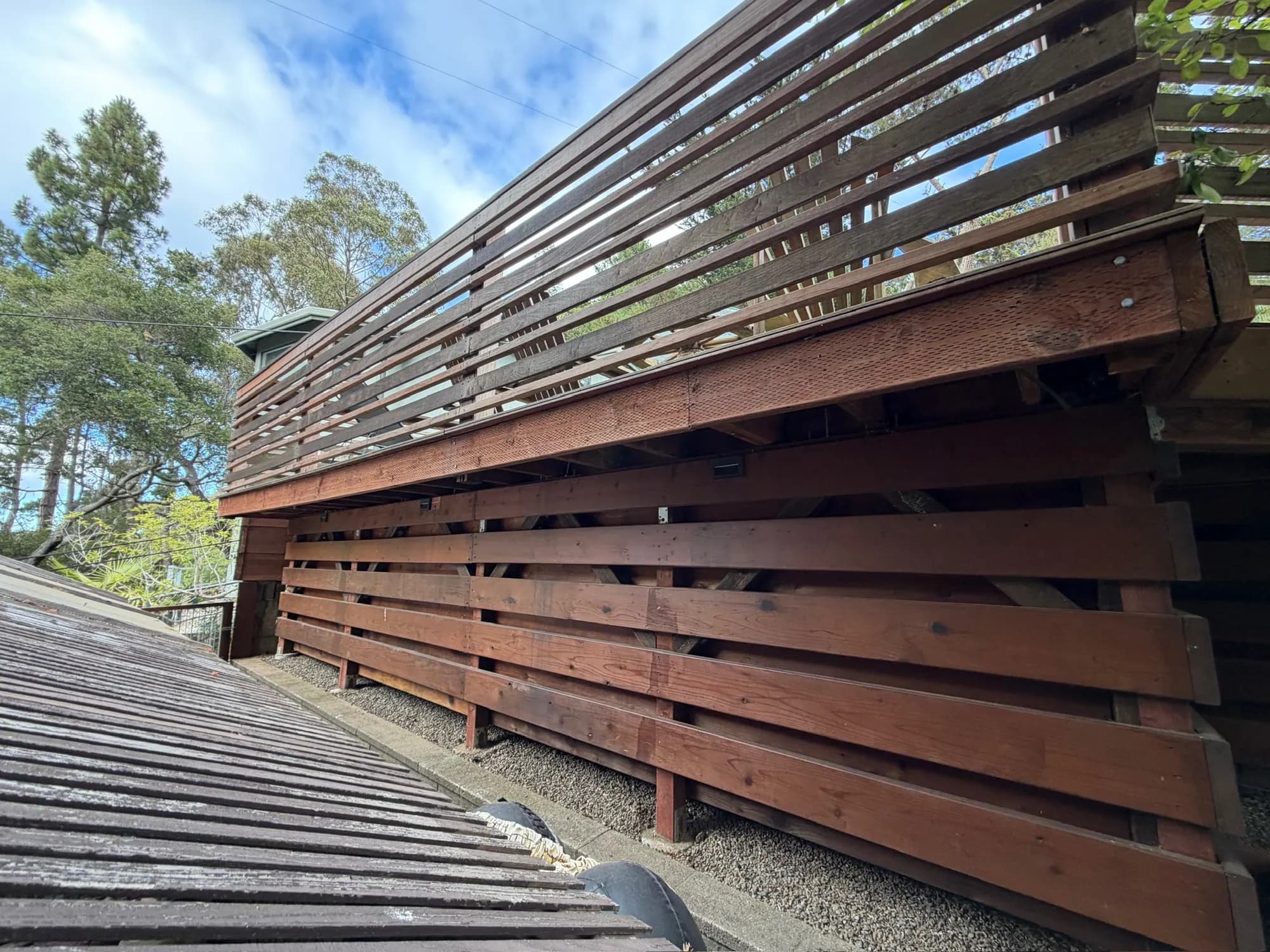 Long run of the elevated pool deck with slatted screening, from the roof edge