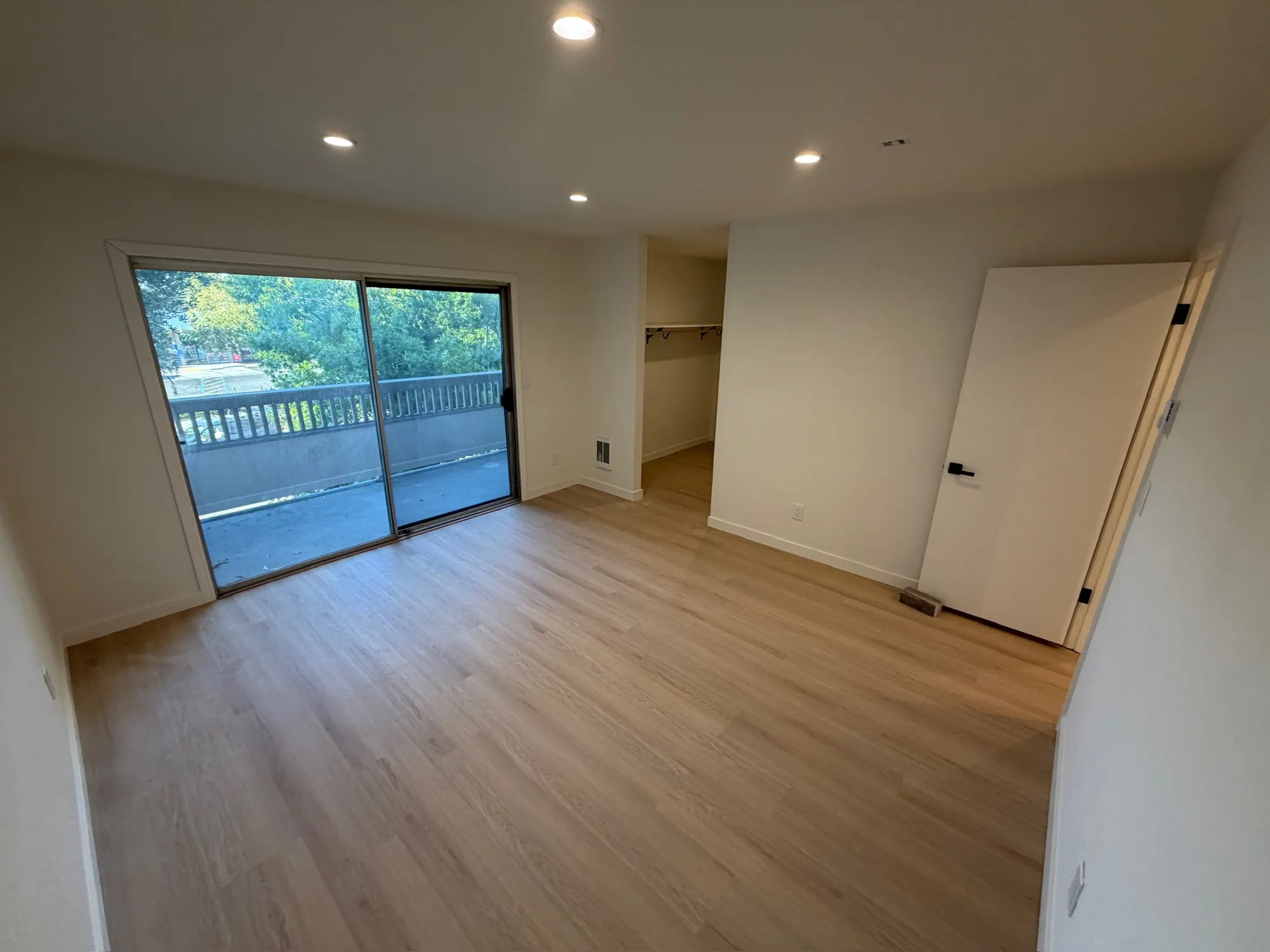 Bedroom with a sliding door to the balcony, new floors and fresh paint
