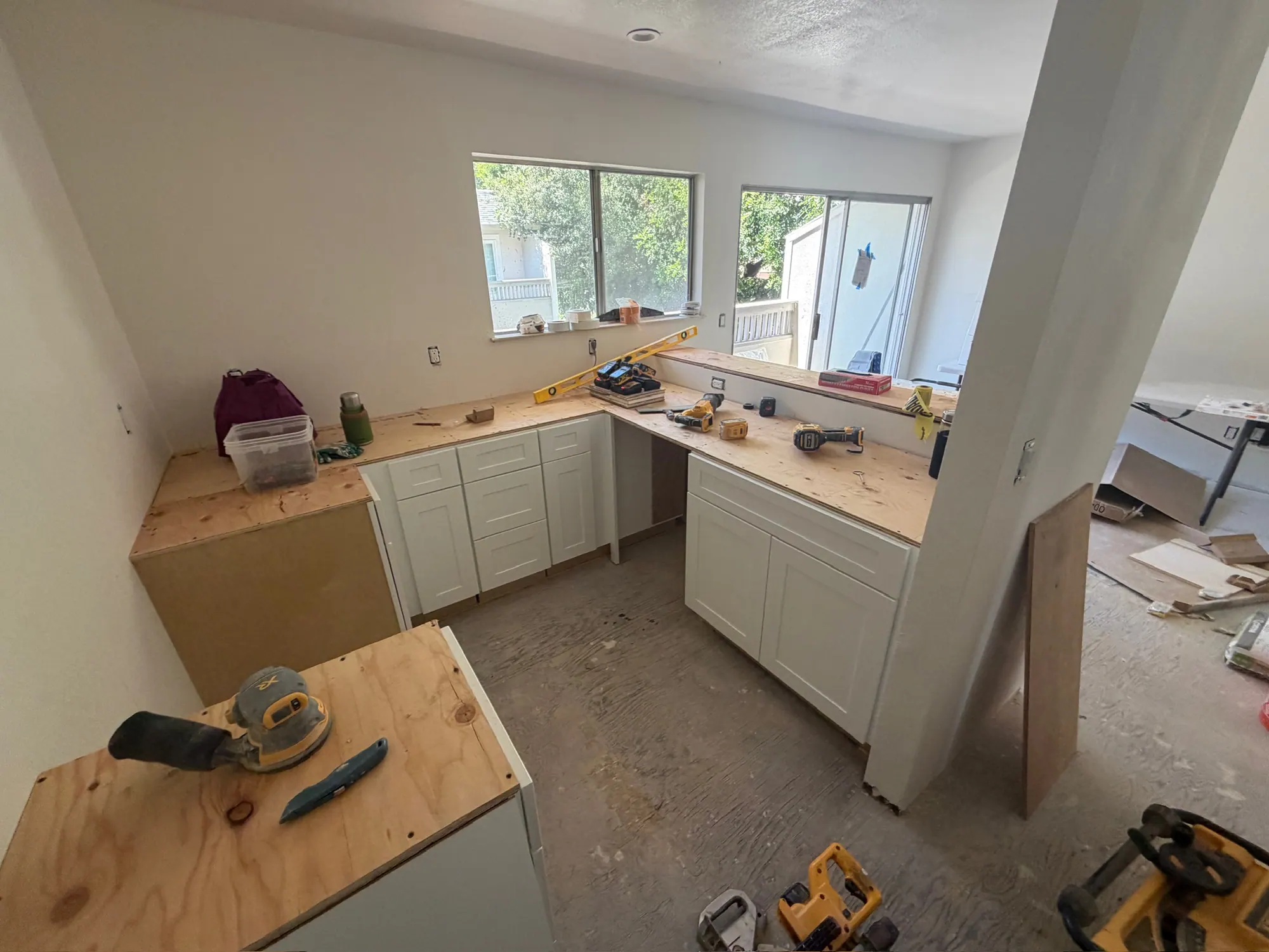 Kitchen cabinets going in, with tools and countertop templates on site