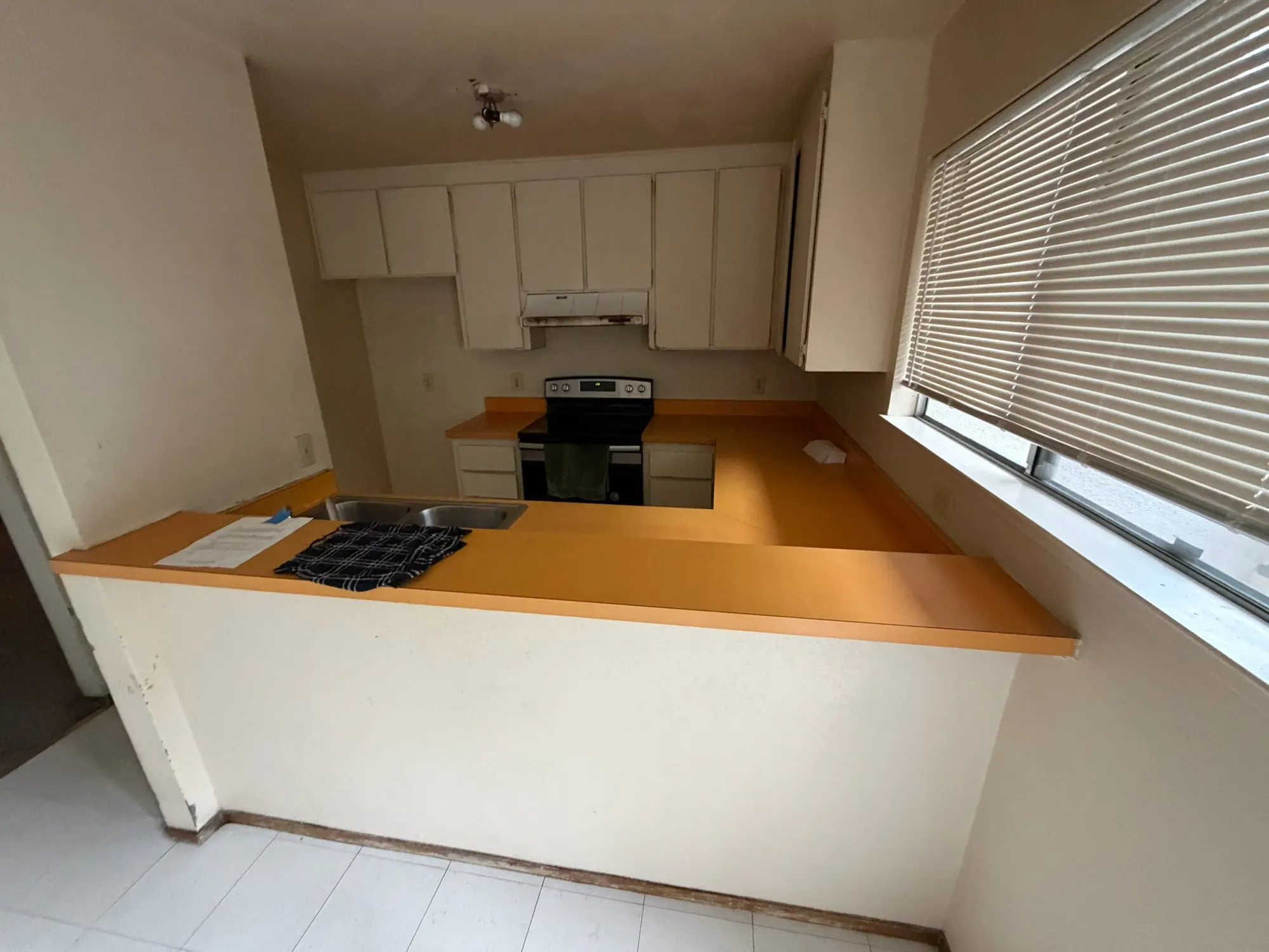 The original kitchen before the renovation, with orange laminate counters