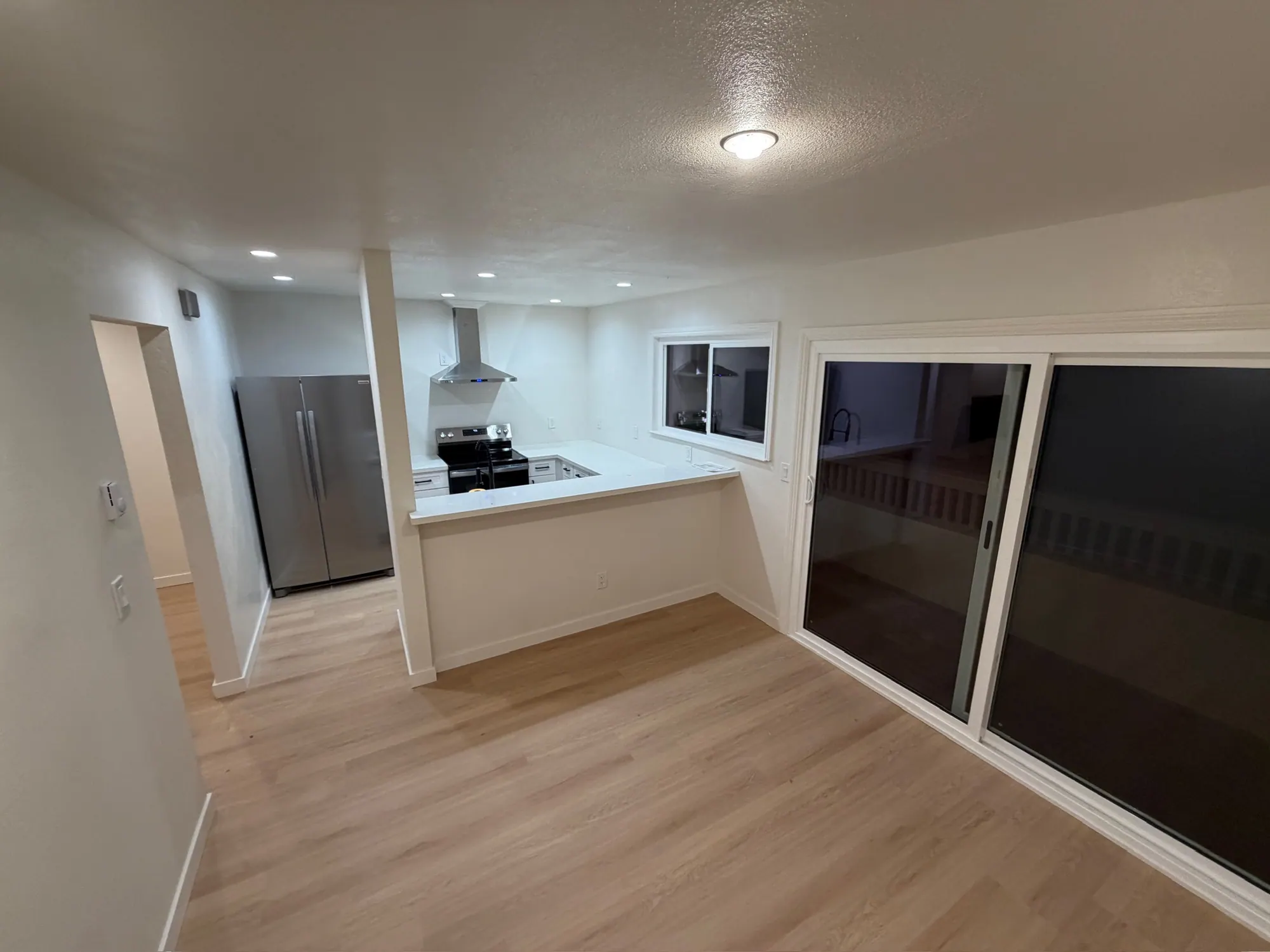 Open kitchen and dining area after the renovation, with a sliding door