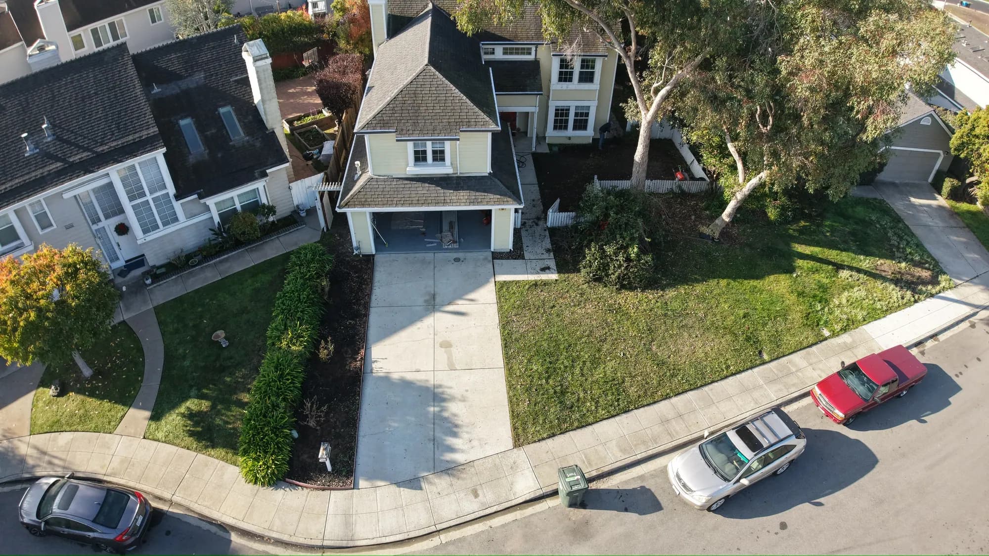 Drone view of the front of the house, its driveway and lawn from the street
