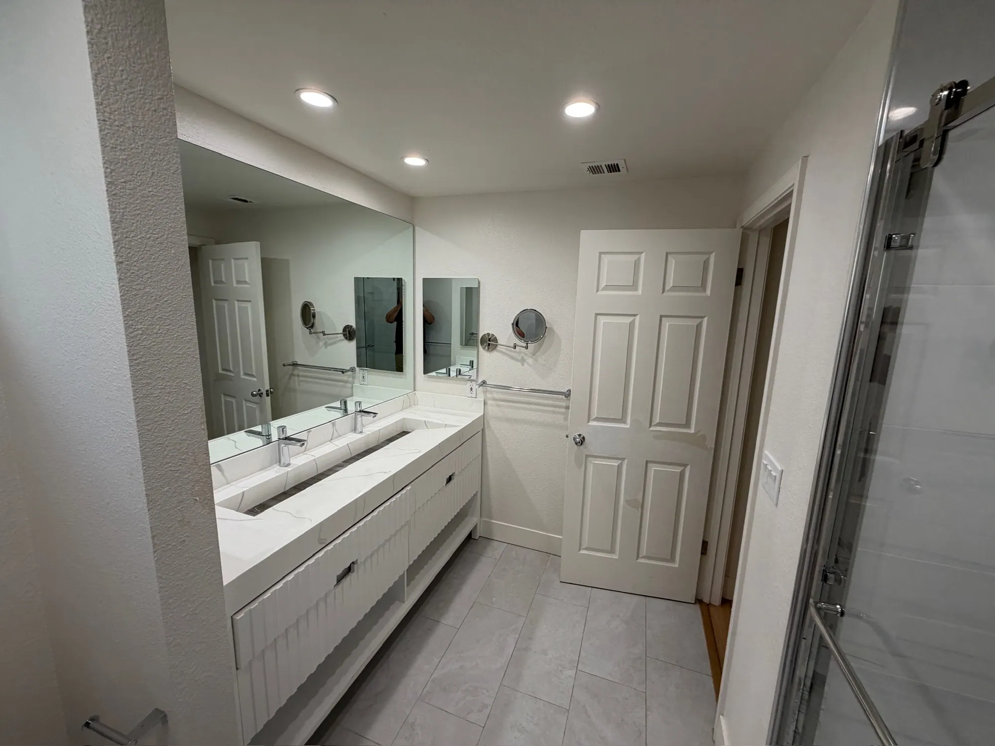 Bathroom with a double vanity, large mirror and tiled floor