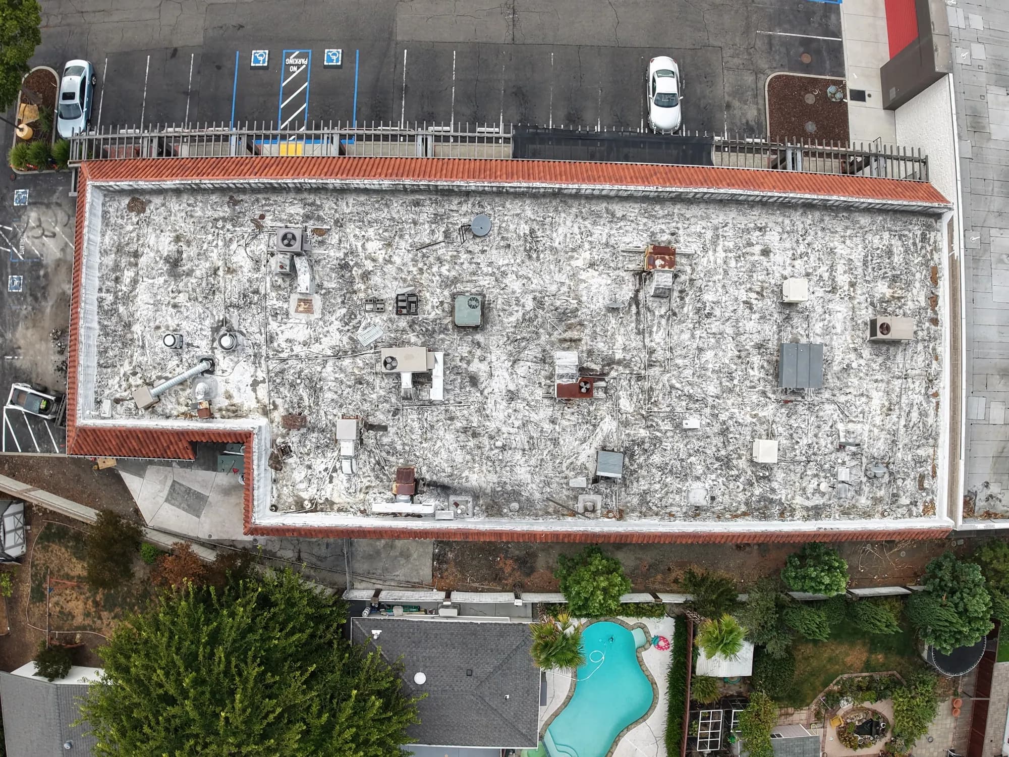 Straight-down view of a weathered, patched flat roof before recoating